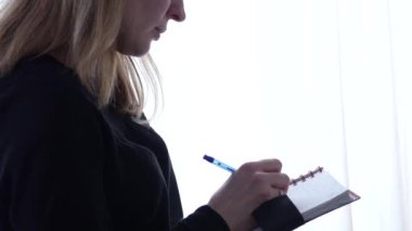 dalgın kız öğrenci bir defter veya günlük notlar yapar. 4k