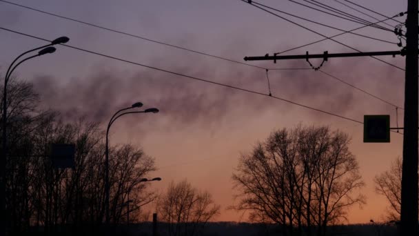 Humo negro de las tuberías de la fábrica sobre un fondo al atardecer en la ciudad. Concepto de contaminación atmosférica. 4K — Vídeo de stock