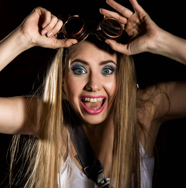 Joven mujer sexy impulsiva con gafas de soldadura sobre un fondo oscuro — Foto de Stock