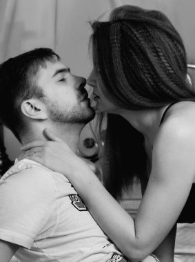 Genç güzel sevgi dolu çift yatağa benimsemiş. tutkuyla öpüşme şehvetli çift ön sevişme ntimate görüntüsü. siyah ve beyaz