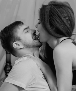 Genç güzel sevgi dolu çift yatağa benimsemiş. tutkuyla öpüşme şehvetli çift ön sevişme ntimate görüntüsü. siyah ve beyaz