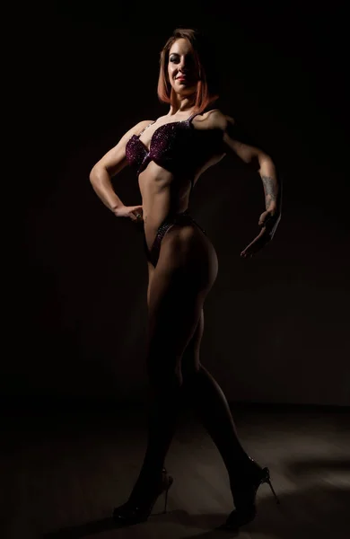 Attraente donna fitness, muscoli giovane atleta su sfondo scuro — Foto Stock