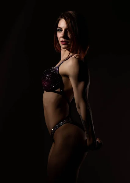 Hermosa mujer fitness, chica muscular posa sobre fondo oscuro. culturismo femenino —  Fotos de Stock