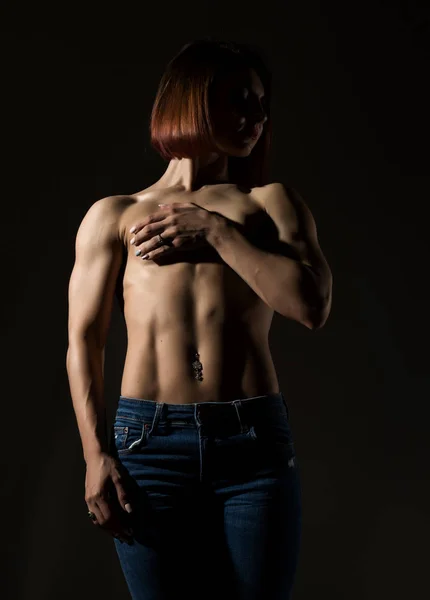 어두운 배경에서 근육 질 몸매로 젊은 여성 모델 포즈 — 스톡 사진