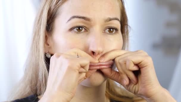 Preventie van huidveroudering, vrouw voert oefeningen voor de bouw van een gezicht. versterking van de spieren rond de lippen — Stockvideo