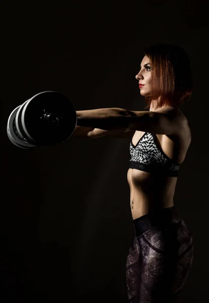 Dumbbellson는 어두운 배경으로 스포츠웨어에 젊은 체육 여자 — 스톡 사진