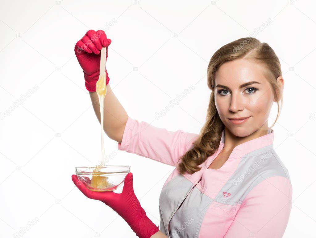 shugaring master in red gloves holds Wand with shugaring wax. depilation and beauty concept