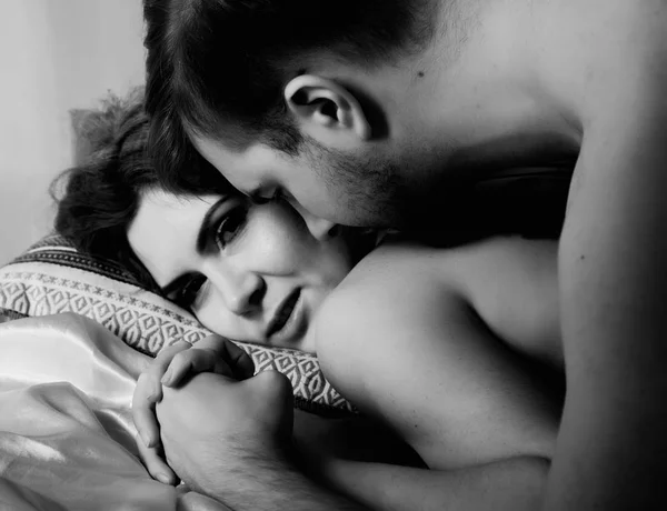 Unga vackra älskande par omfamnar på en säng. ntimate bild av sensuell par förspel, Kysser passionerat. svart och vitt — Stockfoto