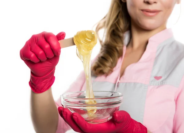 Kırmızı eldiven shugaring master asa shugaring balmumu ile tutar. Epilasyon ve güzellik kavramı