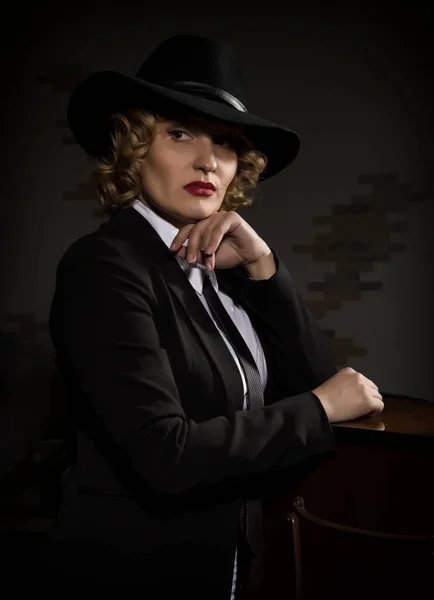 Elegáns nő kalapot öltöny jelent egy sötét háttér, stilizált retro portré — Stock Fotó