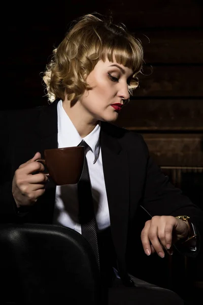 사업가 어두운 배경에서 커피 한잔과 함께. 비즈니스 정장에 여자. — 스톡 사진