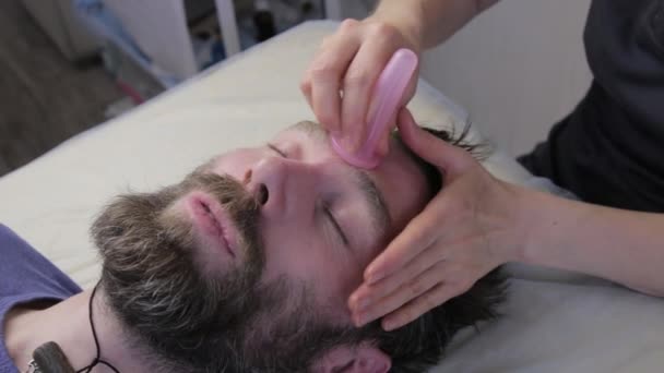 Мужчине делают массаж лица. косметическая процедура, профилактика старения кожи. вакуумный массаж с помощью чашек — стоковое видео