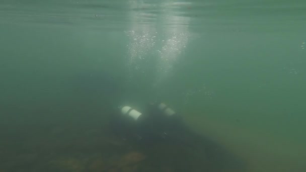 Potápěči prozkoumají skalnaté dno v mělké vodě. mladé cvičení potápěčů. Zpomaleně. potopení do horského jezera — Stock video