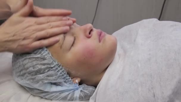 Spa masaje facial adolescente. Masaje facial en salón de spa de belleza. chica joven con problemas de piel en la esteticista. Cuidado corporal, cuidado de la piel, bienestar, tratamiento de belleza . — Vídeo de stock