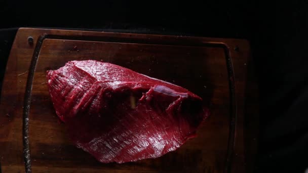 La carne fresca de solomillo crudo se encuentra en una tabla de cortar, lista para asar, condimentar un pedazo de carne — Vídeo de stock