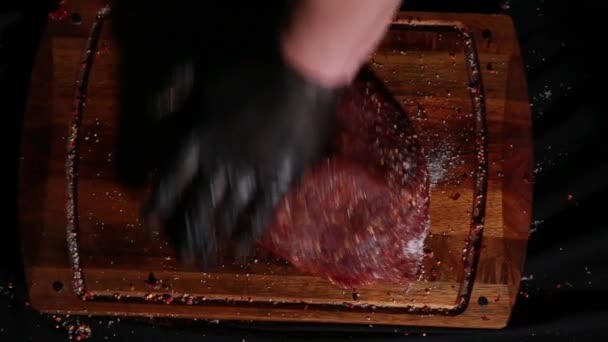 Chef rub up a piece of meat with spices, fresh raw sirloin lies on a cutting board, ready for roasting — Stock Video