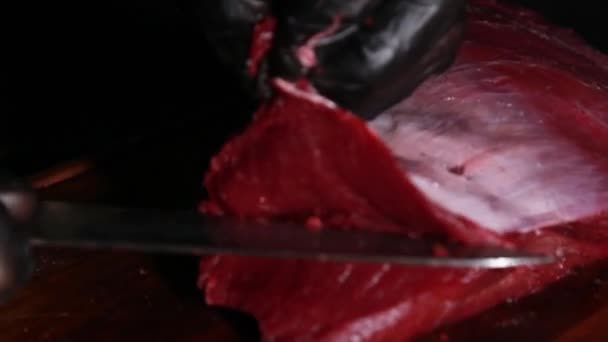 Koki menyiapkan daging untuk dipanggang. Tangan tukang daging memotong irisan daging dengan pisau. tampilan atas — Stok Video