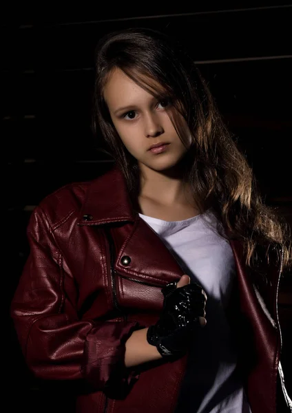 Schöne Mädchen in Lederjacke in einem dunklen. Geheimnisvolles ungehorsames Kind, Probleme mit früh heranwachsenden Mädchen — Stockfoto