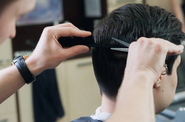 Usta Kuaför berber dükkanı bir kısa yol genç adam kesme. Berber, sandalyeye oturma parlak pelerinli esmer istemci.