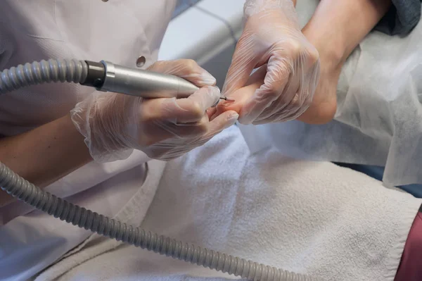 Técnico de uñas profesional lijando clavos con máquina — Foto de Stock