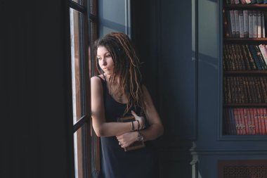 genç kız düşünce penceresinde ayakta Kitaplığı ' nda