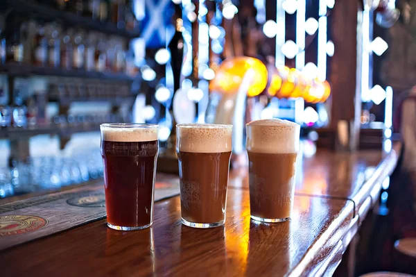 three varieties of freshly brewed natural beer on a dark pub