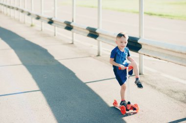 Şehir Park, açık havada bir scooter üzerinde küçük çocuk