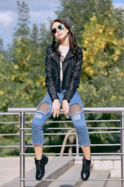 rock tarzı kıyafet, siyah deri ceket, kot, hırpalanmış kot altında bir kılavuzda tayt moda genç kadın