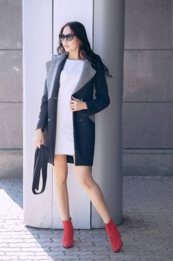 Genç güzel bir moda kadın, açık havada açık portresi. Bir model bir şık gri ceket, güneş gözlüğü giyinmiş. Kadın moda, kentsel yaşam tarzı kavramı