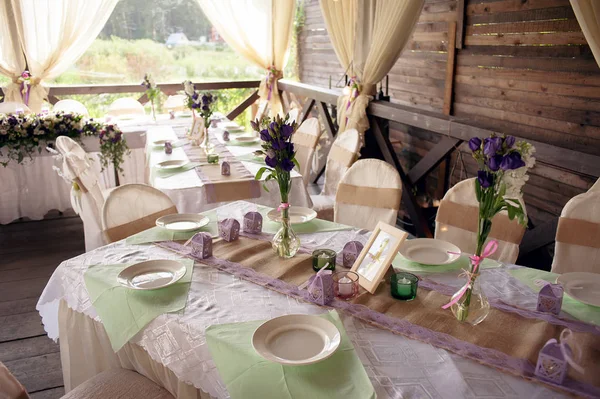 Beautifully decorated table for the wedding ceremony. Served banquet table decorated with fresh flowers in the open air