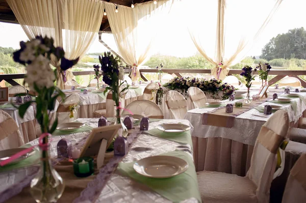 Beautifully decorated table for the wedding ceremony. Served banquet table decorated with fresh flowers in the open air