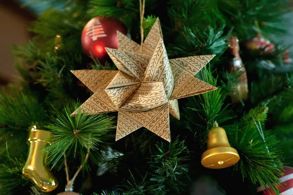 Paper, Christmas, six-pointed star on the branch of blue spruce, together with New Years toys — Stock Photo, Image