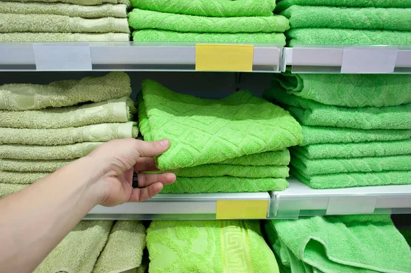 Alıcı renkli banyo havlusu mağaza sayacı tezgahın üzerine alır. Satılık — Stok fotoğraf