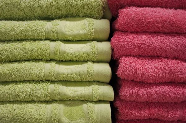 Toallas de baño de colores brillantes en una fila en una fila en el mostrador de una tienda. Venta — Foto de Stock