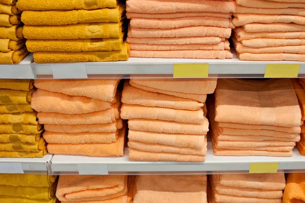 Toallas de baño de colores brillantes en una fila en una fila en el mostrador de una tienda. Venta — Foto de Stock