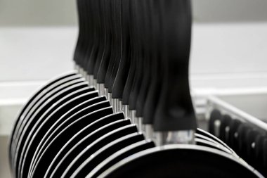 Depodaki bir satır tava yeni asılı. mutfak aletleri