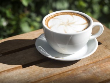 Ahşap masa, yumuşak odak gözlüklerle kahve fincanı