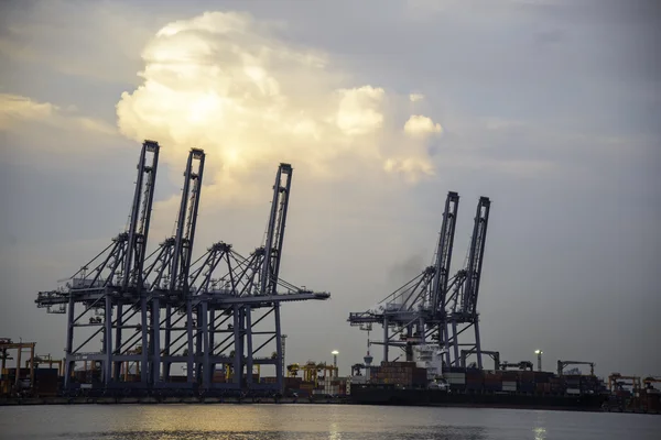 Navio de carga de contentor com ponte de guindaste de trabalho no estaleiro ao entardecer — Fotografia de Stock