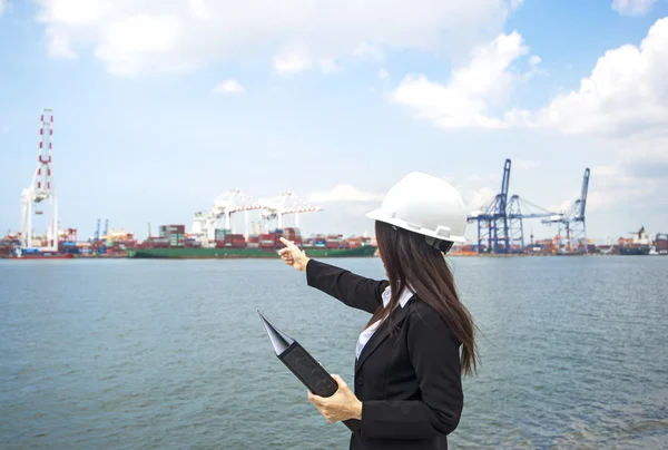 A nők mérnök dolgozik konténer szállítási teherhajó a hajógyár alkonyatkor importálása és exportálása logisztikai háttér — Stock Fotó