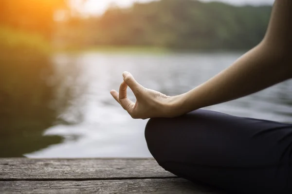 Tutup tangan. Wanita melakukan Yoda outdoor. Perempuan berlatih yoga di latar belakang alam, pilih fokus — Stok Foto