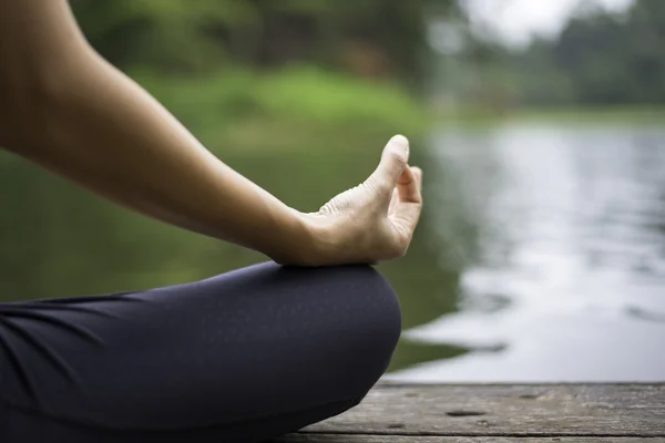 Tutup tangan. Wanita melakukan Yoda outdoor. Perempuan berlatih yoga di latar belakang alam, pilih fokus — Stok Foto