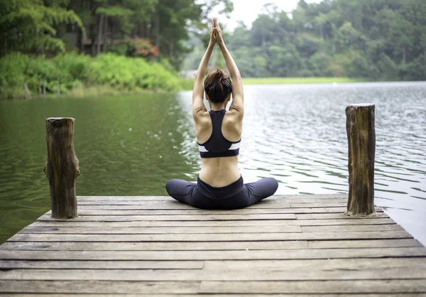Wanita muda yang sehat berlatih yoga di jembatan di alam — Stok Foto