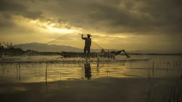 Pescador del lago Bangpra en acción cuando la pesca en la mañana del sol, Tailandia, seleccione el enfoque —  Fotos de Stock