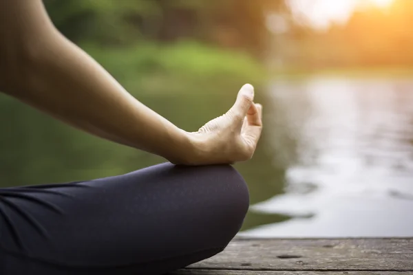 Tutup tangan. Wanita melakukan Yoda outdoor. Perempuan berlatih yoga di latar belakang alam, pilih fokus — Stok Foto