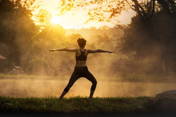 Silhouette einer schönen Yoga-Frau am Morgen im Thermalpark — Stockfoto