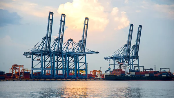 Buque de carga de contenedores con puente de grúa de trabajo en el astillero al atardecer para la exportación de importación logística fondo, seleccione el enfoque —  Fotos de Stock