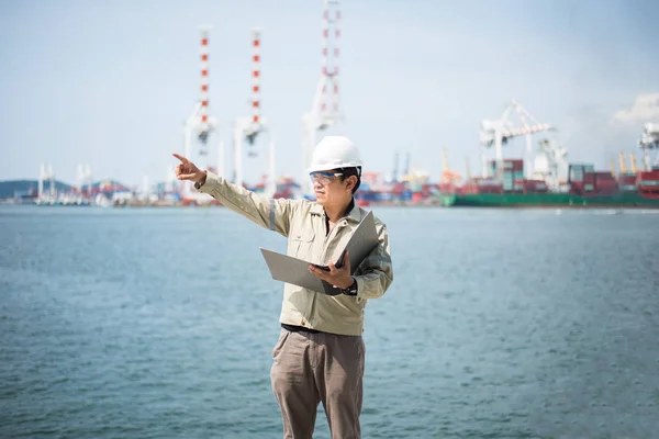 O engenheiro homem que trabalha com contêiner navio de carga no estaleiro ao entardecer para importação logística fundo de exportação — Fotografia de Stock