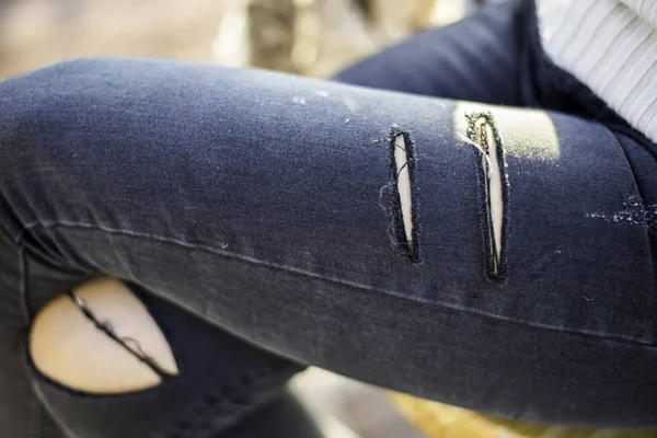 Stylish women sitting in torn jeans. Fashion, lifestyle, beauty, clothing