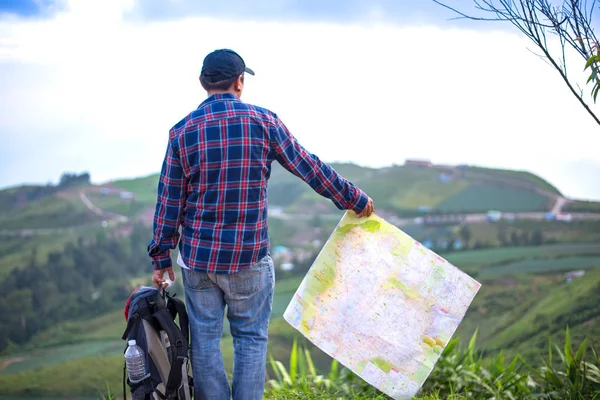 Sırt çantası ile kayıp hiker vahşi alanda yön bulmak için harita denetler — Stok fotoğraf