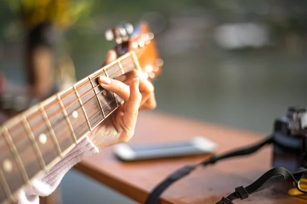 Mãos da mulher tocando guitarra acústica, close-up e selecione o foco — Fotografia de Stock